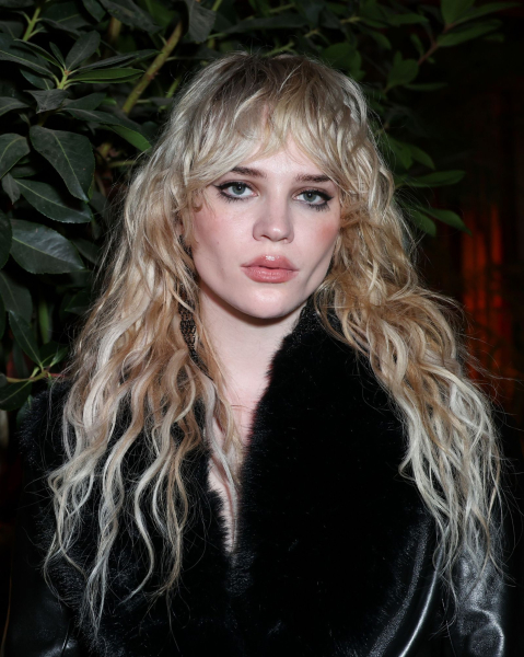 Sophie Thatcher in a long blonde wolf cut and black fur coat